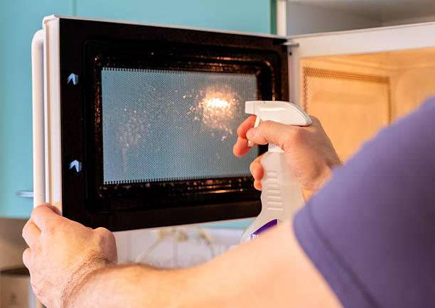 istock Washing and cleaning a microwave oven, human hands and detergent, close-up. 2206991602
