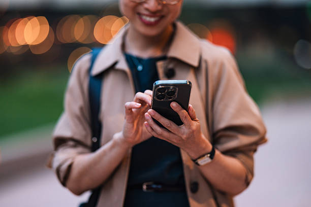 istock Smiling Woman Using Smartphone in Urban Outdoor Setting 2206992578