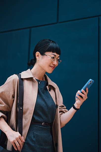 Professional Businesswoman Using Smartphone Outdoors in a City Setting