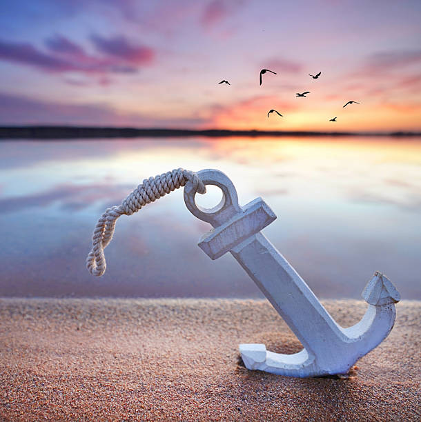 istock summer at the beach, romantic anchor in the sand, sunset light 2206996780