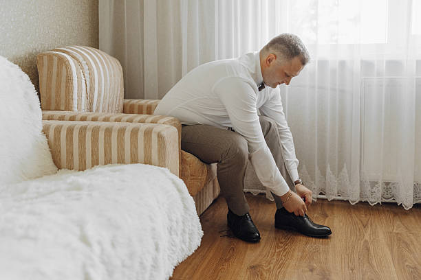 istock A man in a white shirt is getting ready to put on his shoes 2206997473