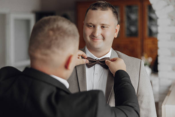 istock A man is getting his tie tied by another man 2206997494