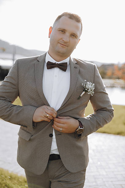 istock A man in a suit and bow tie is adjusting his jacket 2206997512