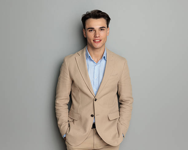 istock handsome young student in his 20s in beige suit holding hands in pockets 2207004916