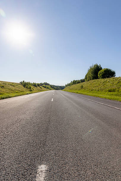 istock an empty straight paved road against a blue sky background 2207005568
