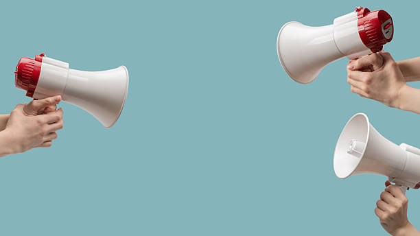 istock Megaphone in woman hands on a blue background. 2207007415