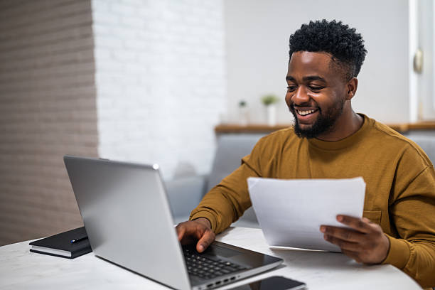istock Black businessman reviewing documents and working online at home 2207008268