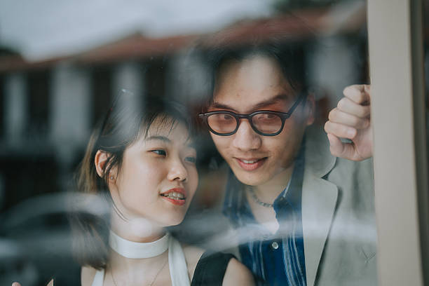Asian Chinese young couple lean on window looking through window
