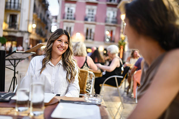 Joyful Females Having Easy Going Conversation While Waiting for Food in Restaurant