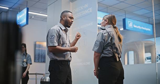 istock Crowded Airport Terminal: Multiethnic Security Staff Standing at Security Checkpoint and Talking 2207012145
