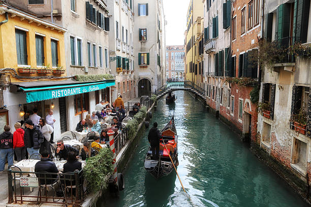 03/01/2025  Venice. Italy.\n\nThe famous restaurant Raffaele close to St Marks Square in one of the smaller channels, full of people eating lunch in the early spring, during the annual carnival in Venice.