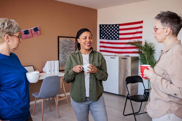 A mid adult Black female army veteran talking to her friends and drinking coffee in a meeting room