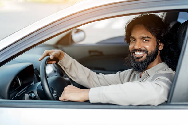 istock Indian man sitting in new car, smiling confidently at camera 2207012653
