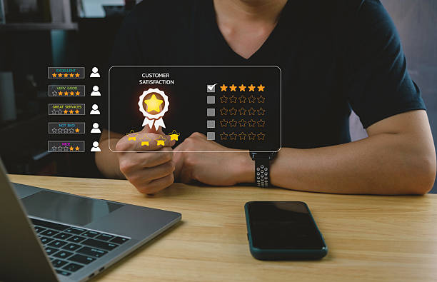 istock A person reviews customer satisfaction metrics on a digital interface while seated at a desk with a laptop and smartphone. 2207012831