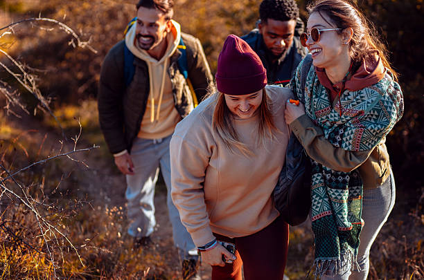 istock Smiling group of friends having fun while hiking together on hill at sunset. 2207013973