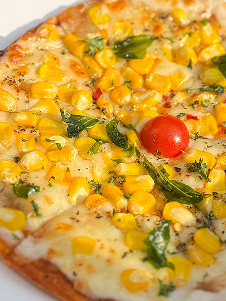 Image of sliced sweetcorn pizza with olives, mozzarella cheese / classic Italian dish, crispy crust, fresh toppings