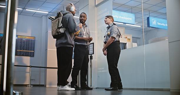 istock Crowded Airport Terminal: Two Multiethnic Security Officers in Uniform Talking 2207014468