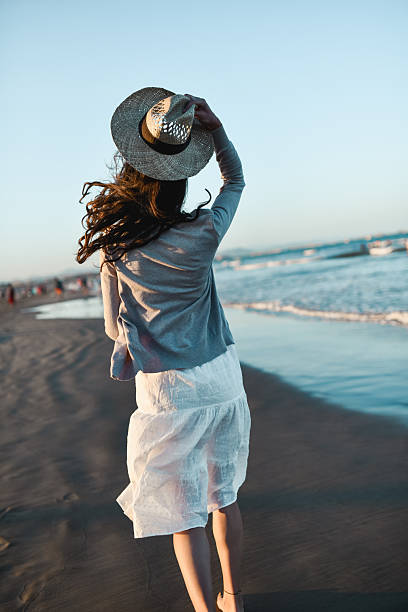 istock Female Enjoying Peaceful Moment on Beach Taking Walk on The Soft Sand 2207017164