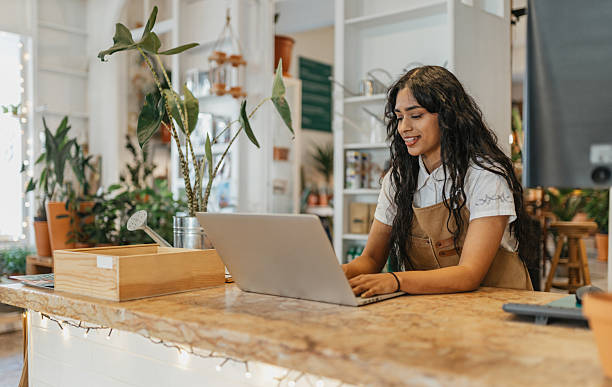 Woman Working on a Laptop in a Bright Shop