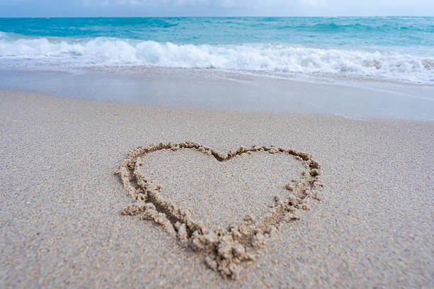 istock Ocean waves background. Tropical ocean waves. Blue seaside view. Heart drawn in sand. Waves forming a heart shape sign. Love on beach. Romantic summer. Heart made of sand. Love and ocean waves. 2207018509