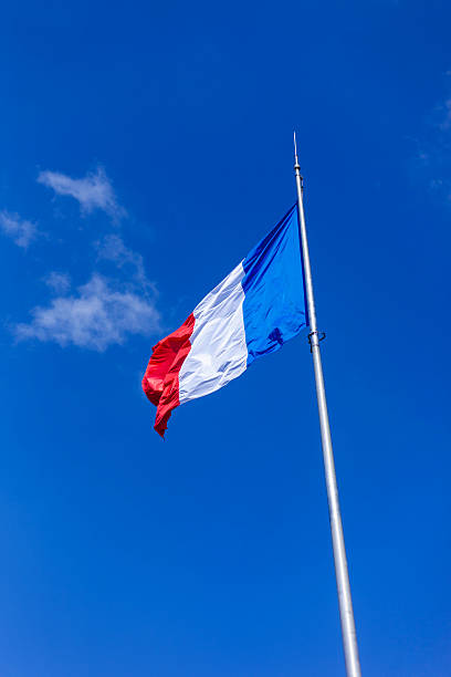 This this photo, the french flag is seen in a blue background sky in belfort France