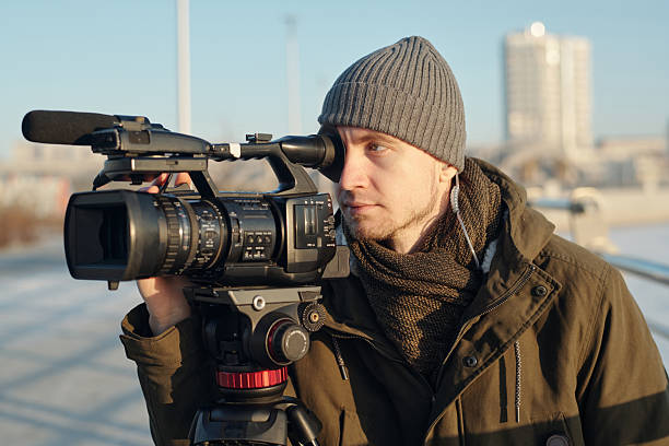 istock Man filming footage on video camera 2207022198
