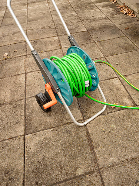 istock a hose reel with a green hose standing on nwely washed cement slabs 2207023306