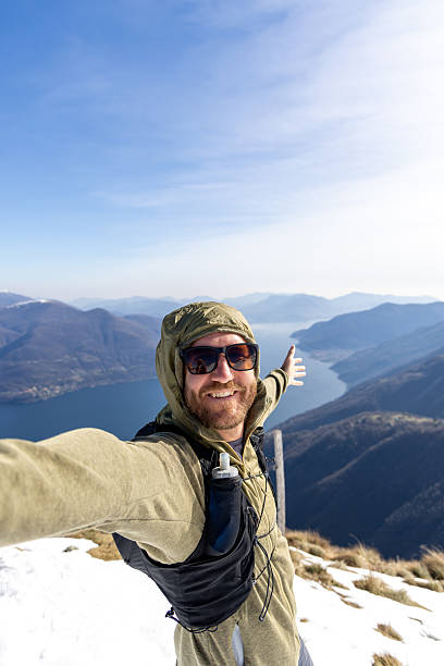 istock Smiling Hiker Taking Selfie on Mountain Peak with Scenic Lake View 2207024395