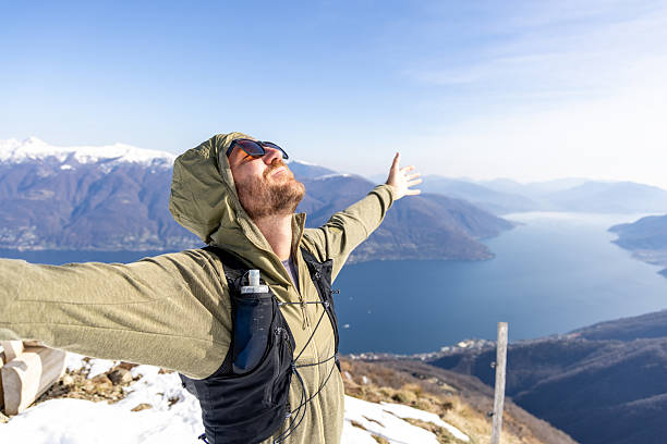 istock Man Embracing Nature on Mountain Summit Overlooking Lake 2207024403