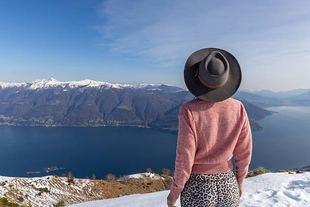 Woman in stylish outfit gazing at breathtaking mountain landscape. Adventurous traveler appreciating nature. Perfect for outdoor or travel themes.