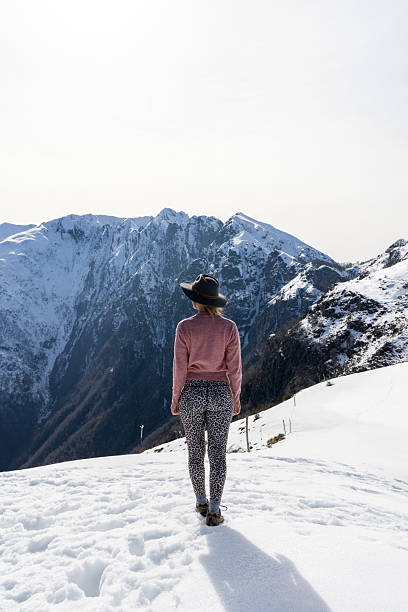 istock Woman Enjoying Scenic Mountain View on Snowy Summit 2207024498