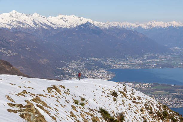 istock Solo Hiker on Snowy Mountain Ridge Overlooking Scenic Valley 2207024528