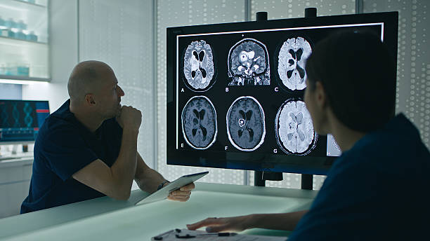 istock Doctor talks with intern and analyzes EEG examination on grand round meeting 2207025012