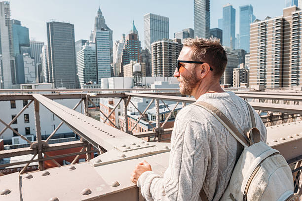istock Man Relaxing on Bridge with Urban Cityscape View 2207025365