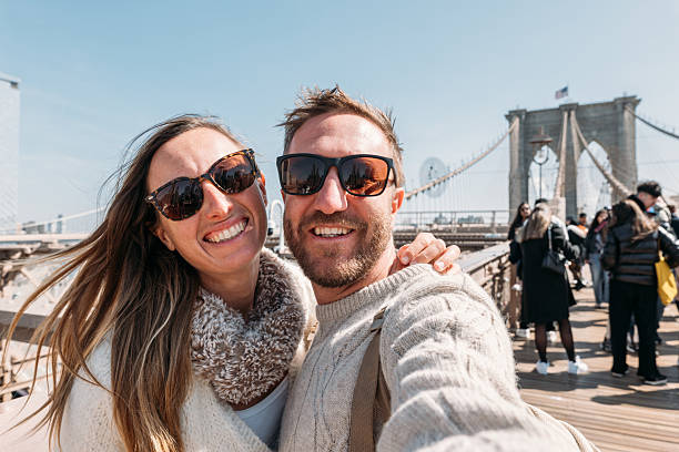 istock Smiling Couple Taking Selfie on Brooklyn Bridge 2207025408