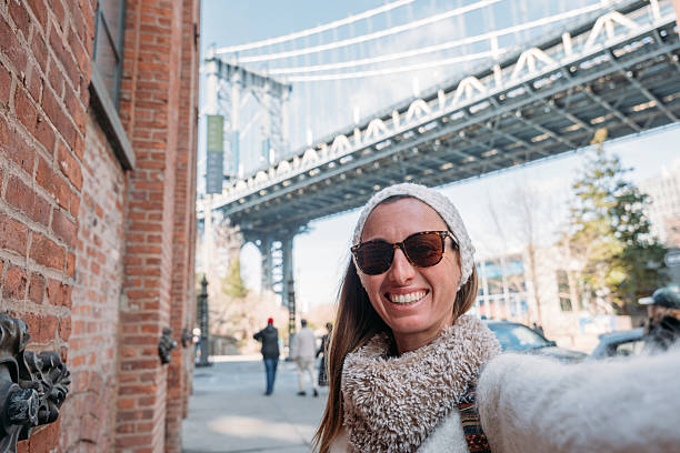 istock Smiling Woman Taking Selfie Under Urban Bridge 2207025435