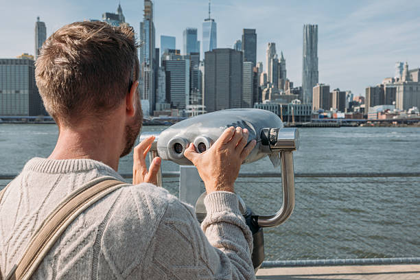 istock Man Viewing City Skyline Through Coin Operated Binoculars 2207025489