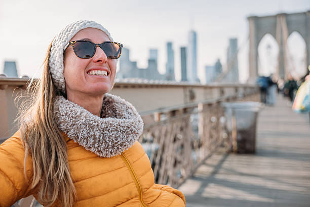 istock Woman Relaxing on Brooklyn Bridge with City Skyline 2207025607