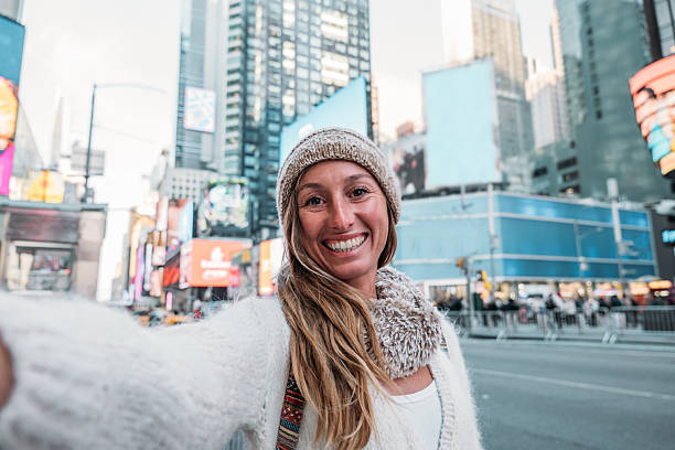 istock Smiling Woman Taking a Selfie in Times Square 2207025746