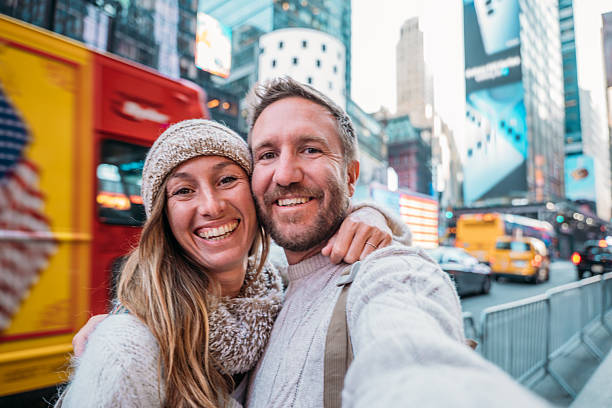 istock Smiling Couple Taking a Selfie in Times Square 2207025769