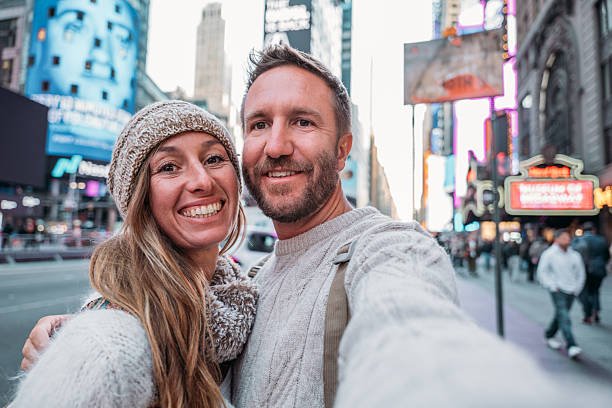 istock Smiling Couple Taking a Selfie in Times Square 2207025775