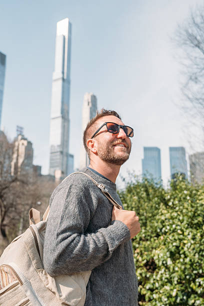 istock Young man enjoying a sunny day in the city with backpack 2207025889