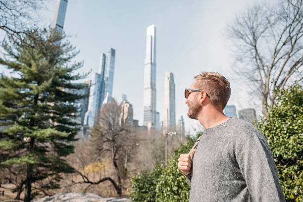 istock Young man enjoying a sunny day in the city with backpack 2207025895