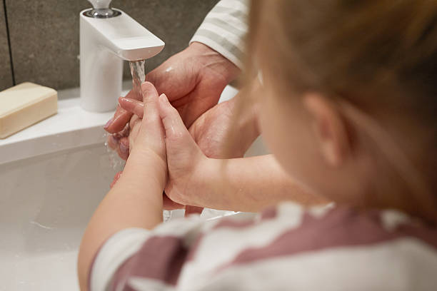 istock Mother Helping Daughter Washing Hands Close Up 2207029963