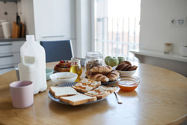Background image of simple homemade breakfast with milk and sandwiches on wooden table in cozy kitchen interior, copy space