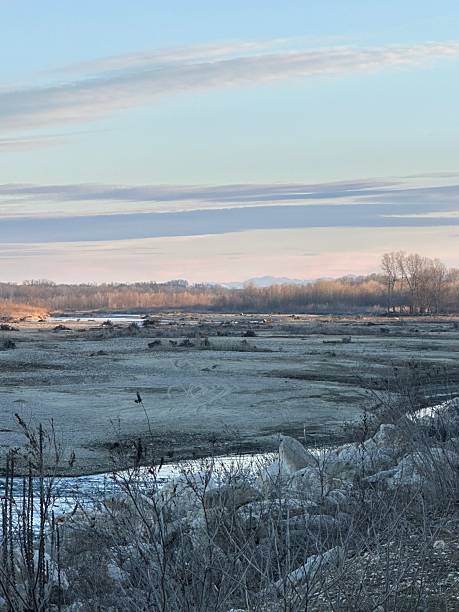 istock Barren Winter Riverbed with Distant Trees and Mountains 2207030974