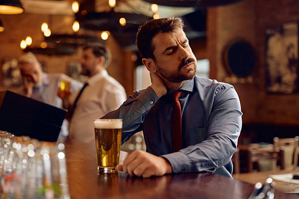istock Exhausted businessman drinking beer in a pub after work. 2207036465