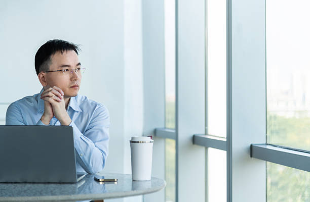 istock Businessman using laptop by the window 2207037459