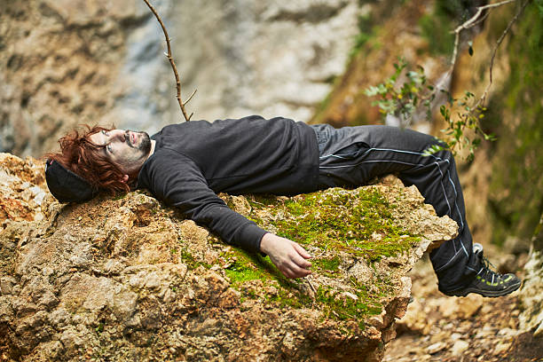 Injured hiker lying on a rock after mountain accident