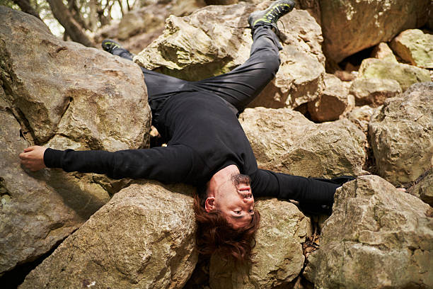 istock Injured hiker lying upside down on rocks after mountain accident 2207038528